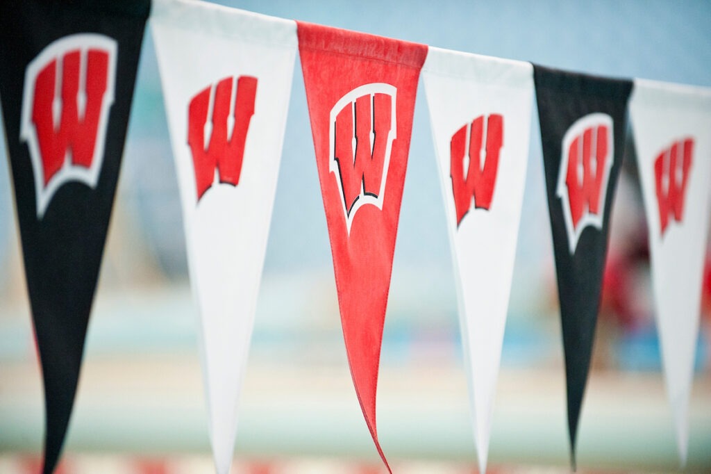 A line of flags featuring the motion W decorate the pool of the Natatorium at the University of Wisconsin-Madison