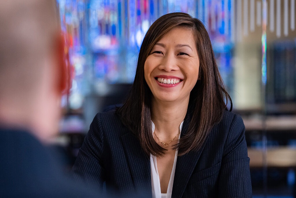 Cynthia smiling at the person's she's in a meeting with