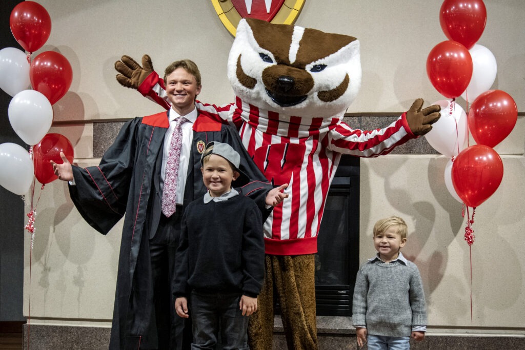 Marketing graduate Dylan Koeshall celebrates with his brothers and Bucky during the winter undergrad commencement ceremony