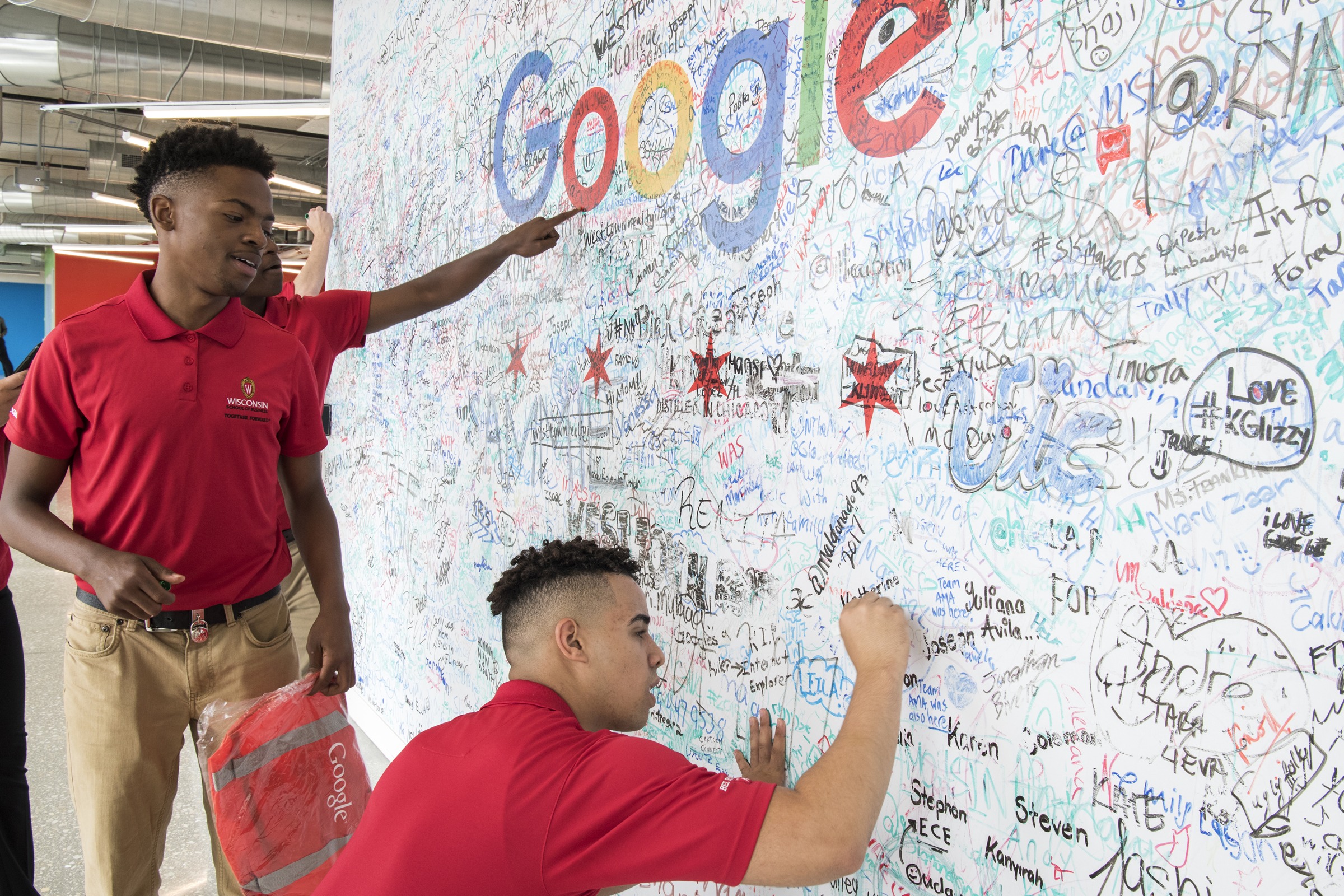 Students drawing on the Google wall