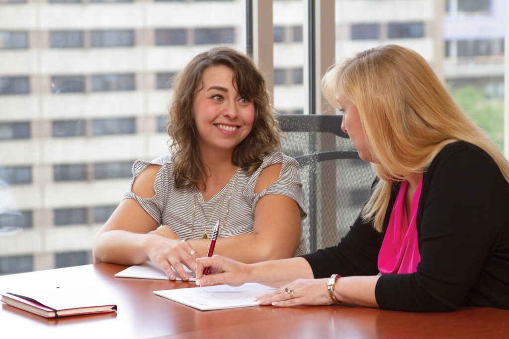 2 women collaborating over table