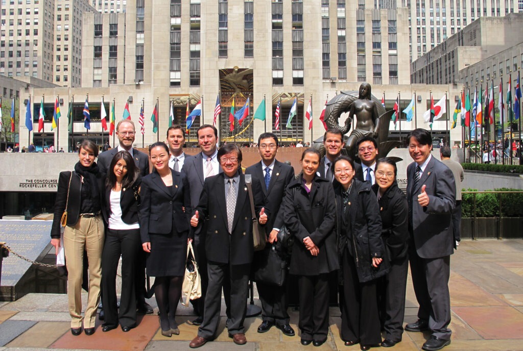 Group of students pose in front of building