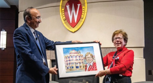 Dean Vallabh “Samba” Sambamurthy presenting Chancellor Blank a drawn portrait of Chancellor Blank standing in front of Grainger Hall.