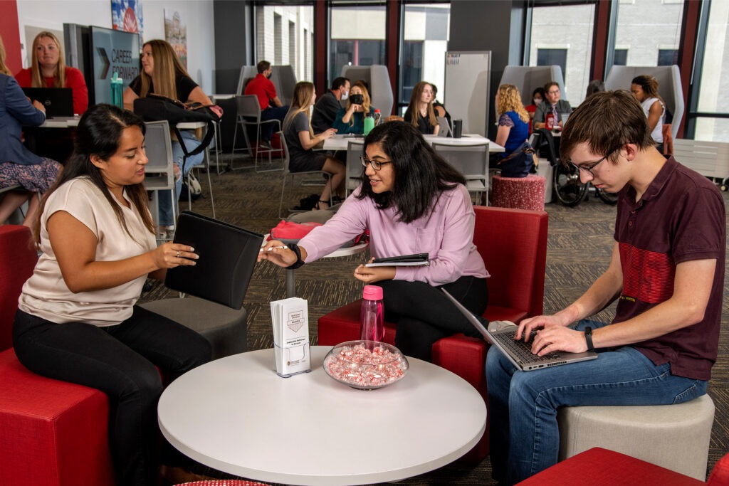 Students chatting at tables in the career engagement studio