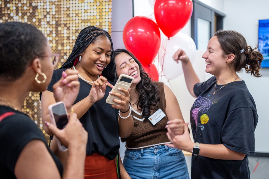 A group of students laugh together at the Multicultural Center grand opening.