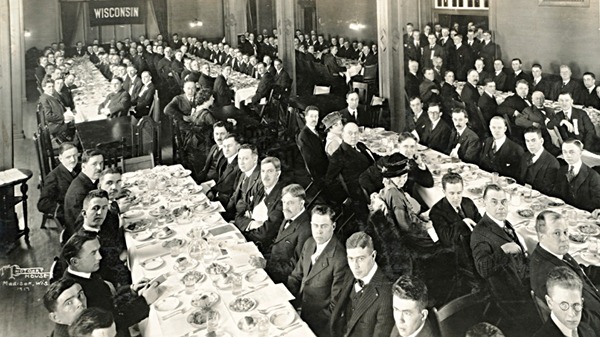 Men sitting at tables looking at the camera during the Commerce Club Banquet