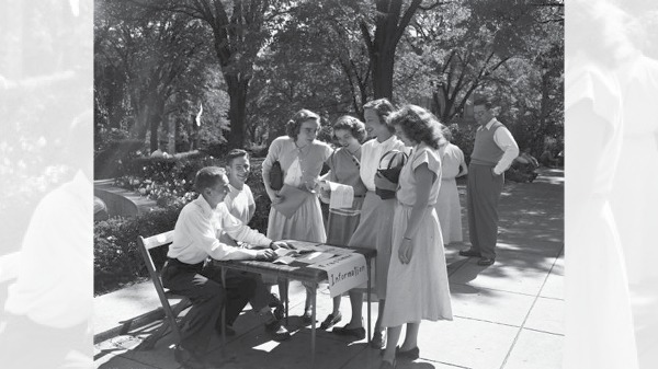 Four women students talking with two volunteer members at a table