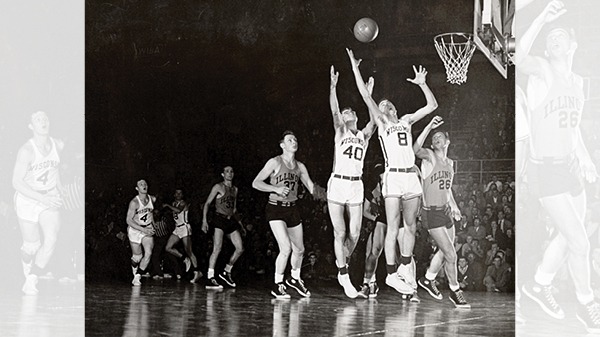 Basketball game with two players on the same team trying to get the ball through the hoop