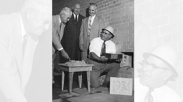 Four men adding the cornerstone for the Commerce building