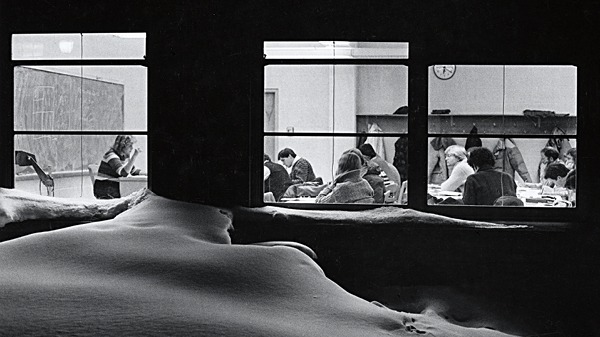 A teacher teaching a class with students sitting at desks