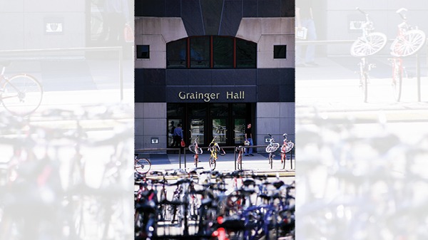 Grainger Hall with bicycles racks filled with bicycles in front of the building