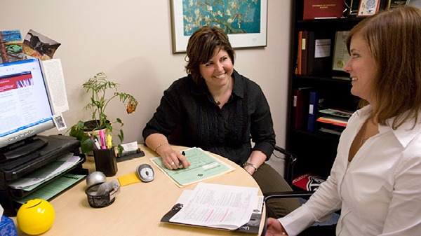 BBA student talking with a student services staff member