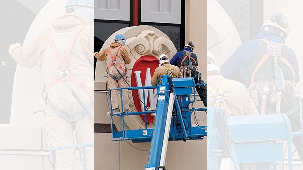 The w crest being installed on Grainger Hall