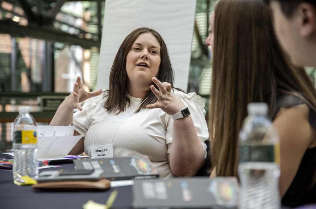 Student gesturing with hands as she explains something to fellow students