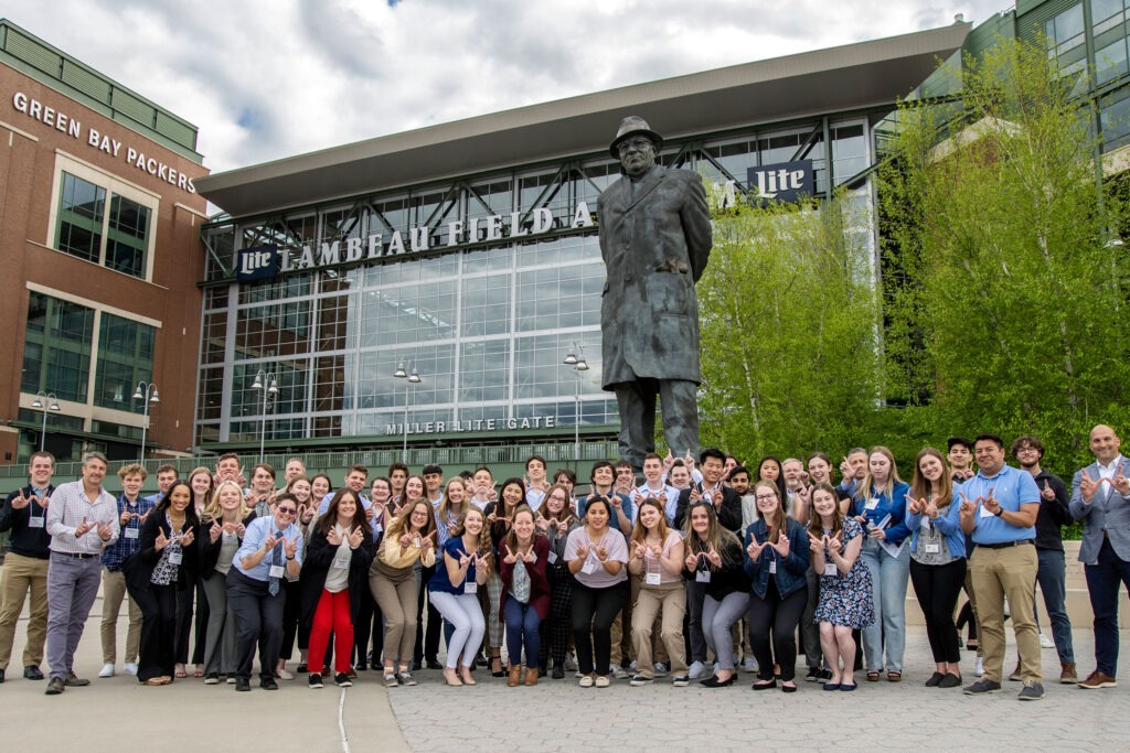 A group of 40 students pose for a photo outside Lambeau Field in Green Bay.