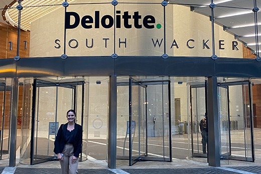 Simone standing in front of Deloitte building