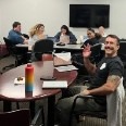 Students studying in the SHR Center. One student is waving at the camera