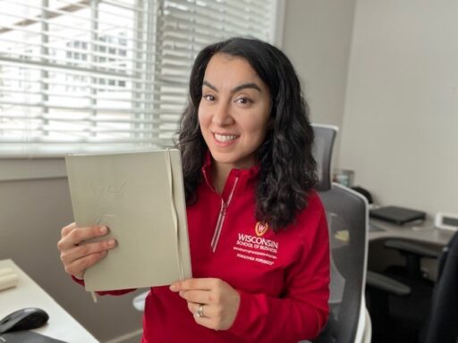 Vicki Villarreal holding her notebook from her MBA program