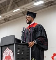 May 2022 BBA graduate, Bryson Williams, stands at lectern and delivers student speaker speech at graduation celebration.