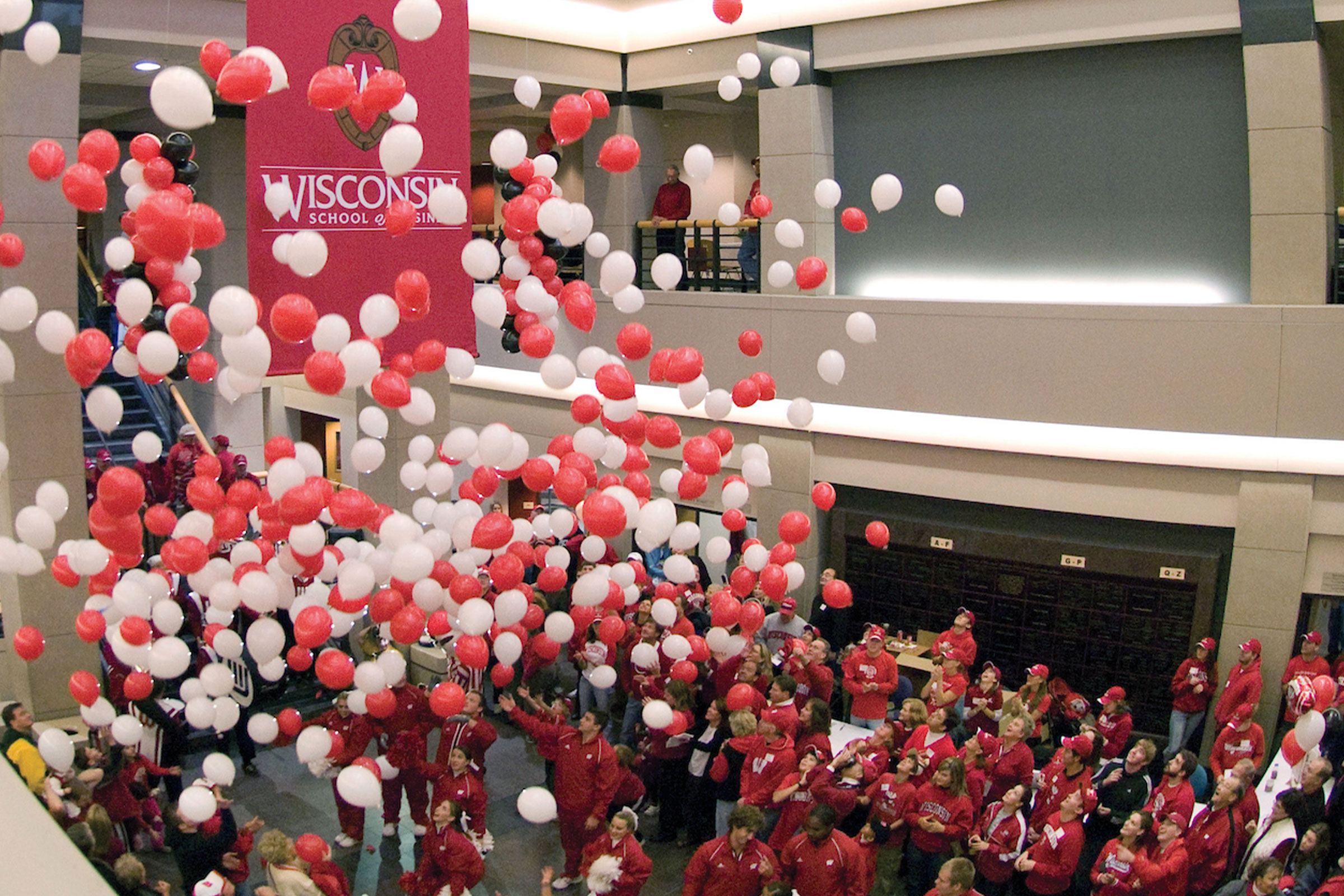 Red and white ballons falling on students in Grainger Hall