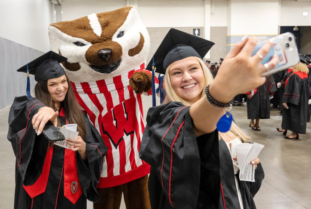 Wisconsin School of Business graduates grab a photo op with Bucky before the Spring 2023 Undergraduate Graduation Celebration ceremony starts on Friday afternoon, May 12, 2023, at the Alliant Energy Center -Expo Center.    (Paul L. Newby, II /UW-Madison Wisconsin School of Business)