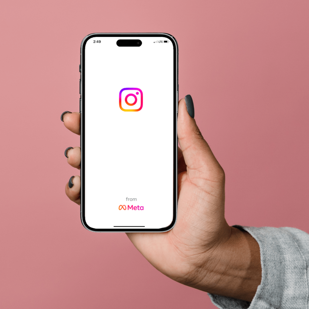 A hand holds up a phone showing the login to Instagram which has "from Meta" branding at the bottom of it. 