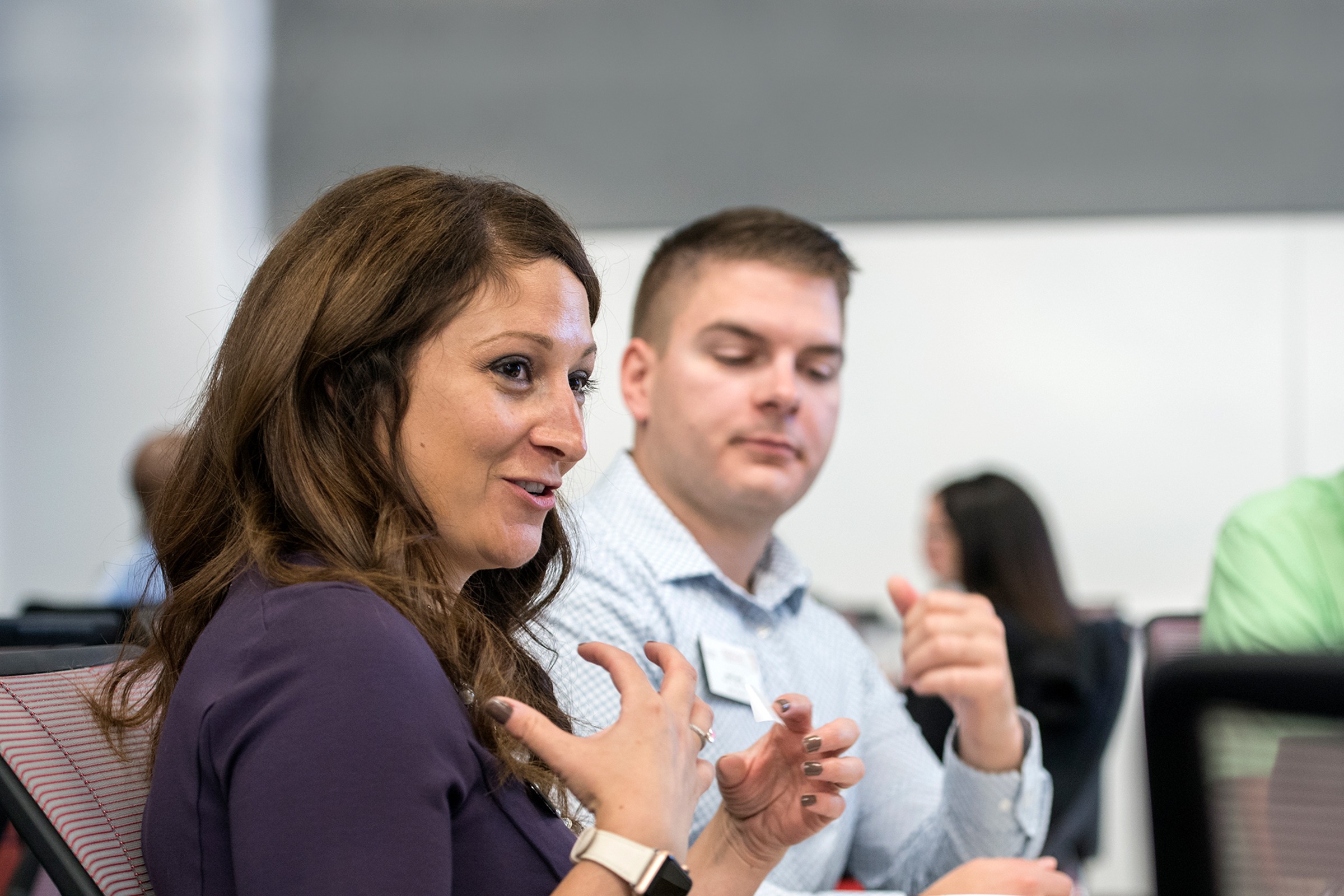 A woman talking while the man next to her listens