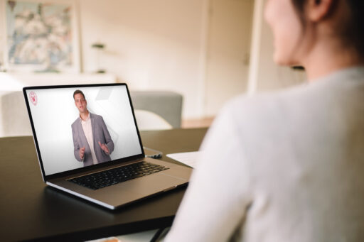 A woman watching an online lecture on her laptop