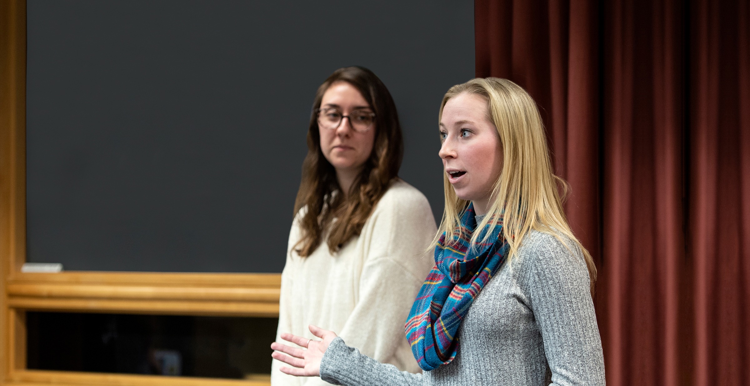 Two students presenting in front of an audience