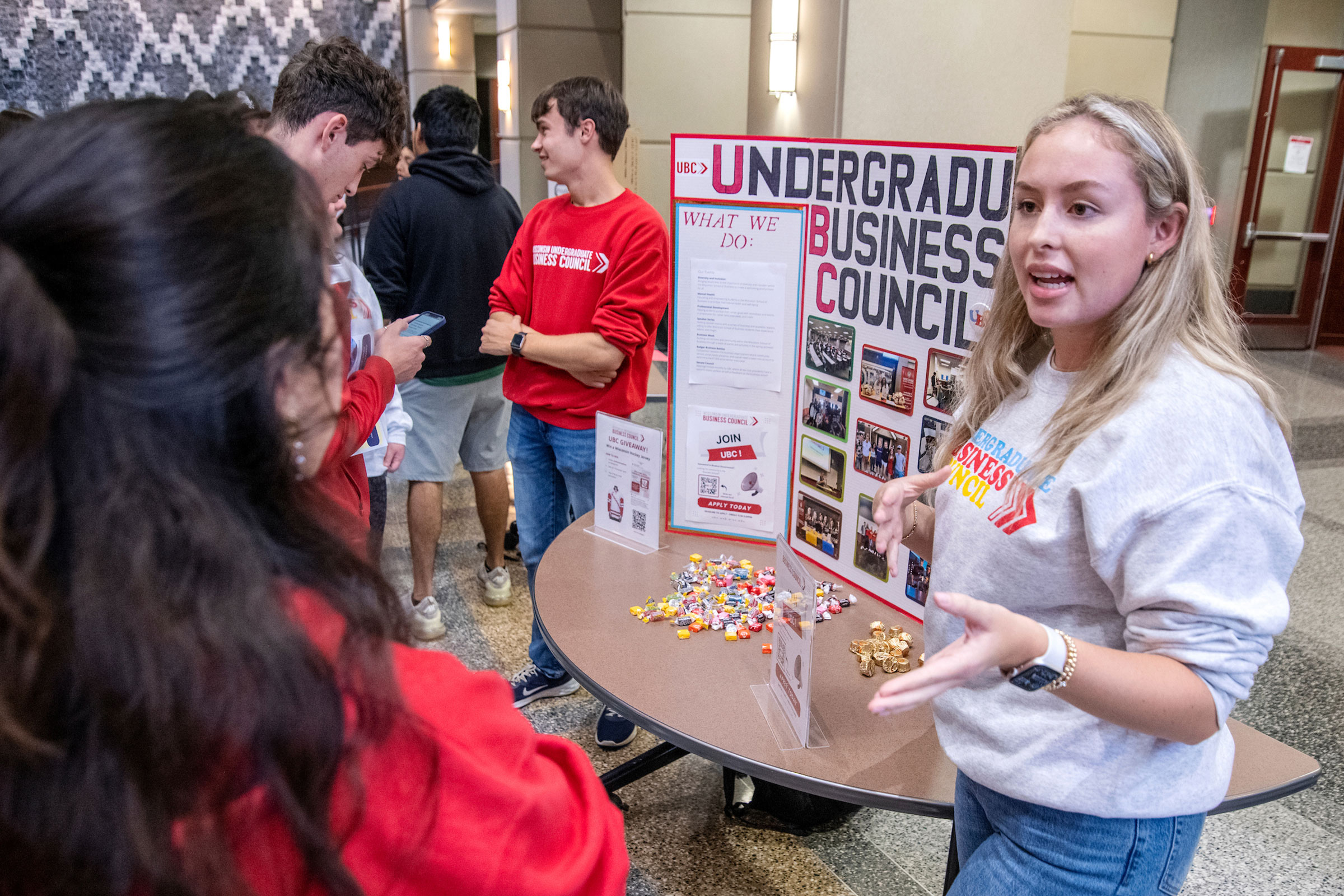 A woman talks to students about the Undergrad Business Council group during the BBA Student Org Fair