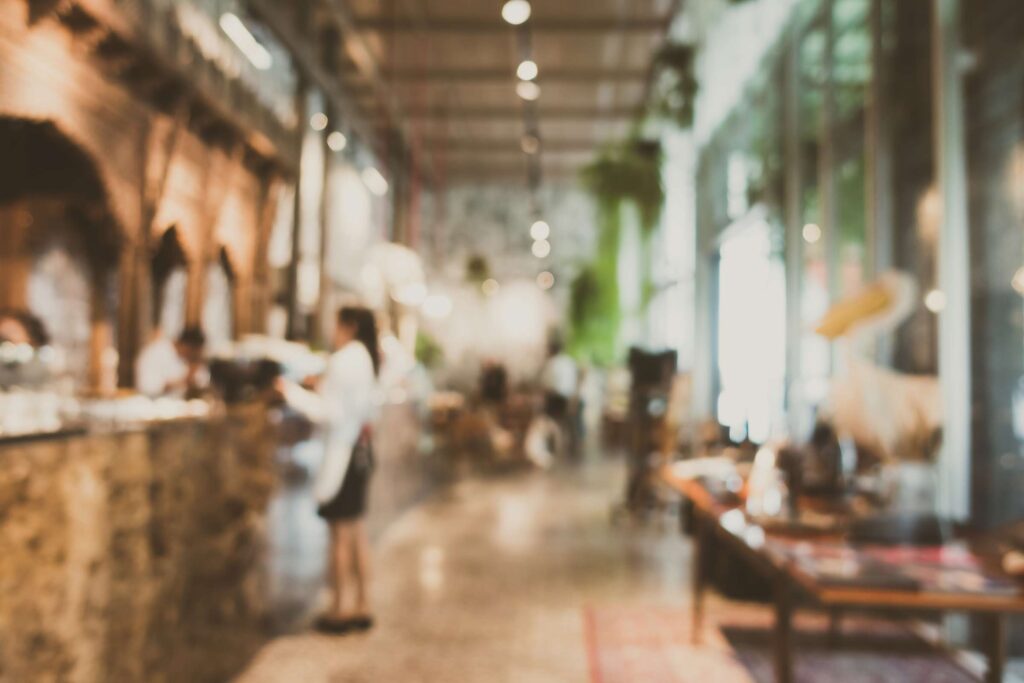 Blurred image of restaurant and server carrying plates