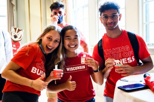 First-year students wearing red UW and WSB shirts enjoy Babcock ice cream at a campus event
