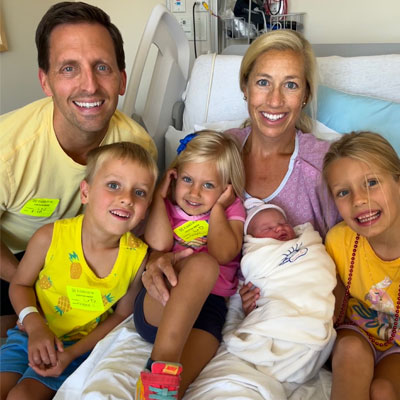 Lavelle and family posing in hospital bed with newborn baby