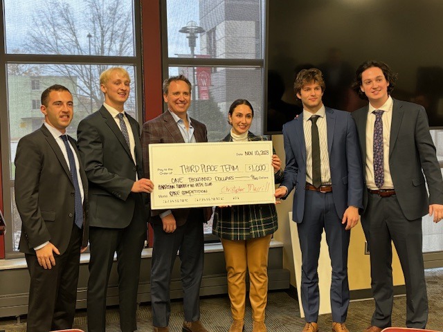 The third place team (Aidan Witte, Aidan McCarthy, Finley Wistom, Noah Heller) holding their check with Brian Mutchler and Amanda Doster of Harrison Street