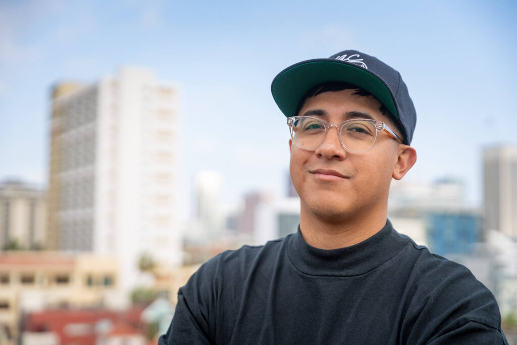 Noe smiling with a blurry skyline behind him