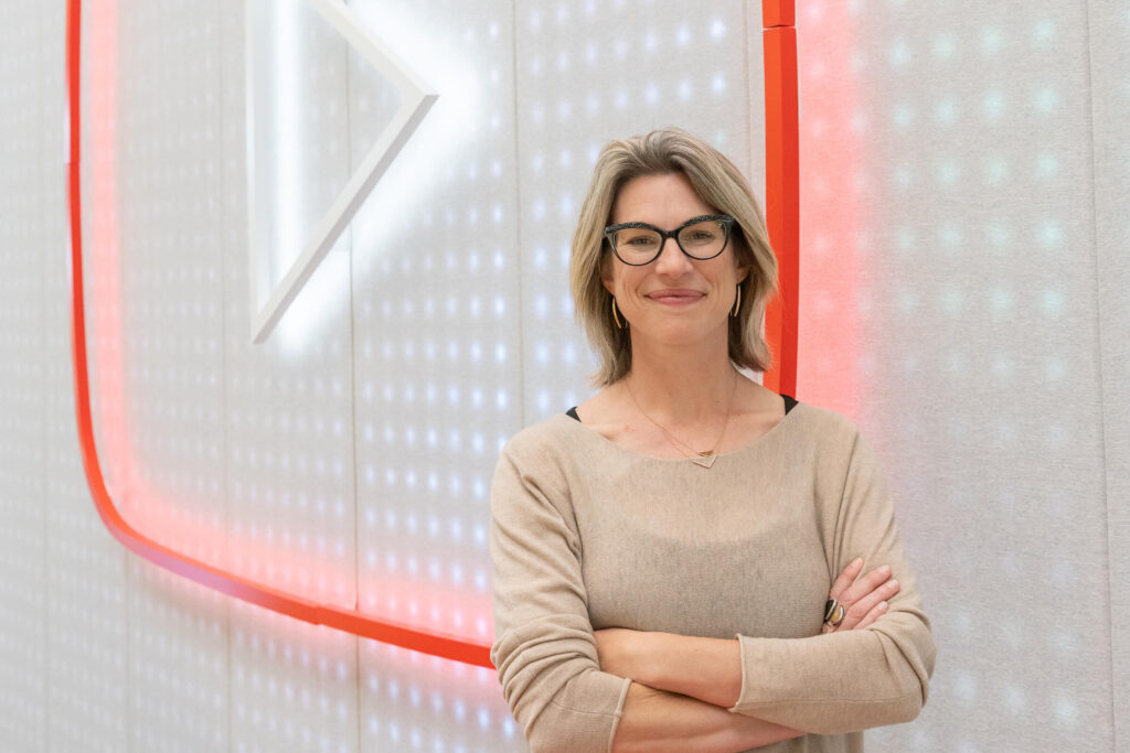Danielle standing in front of the YouTube logo