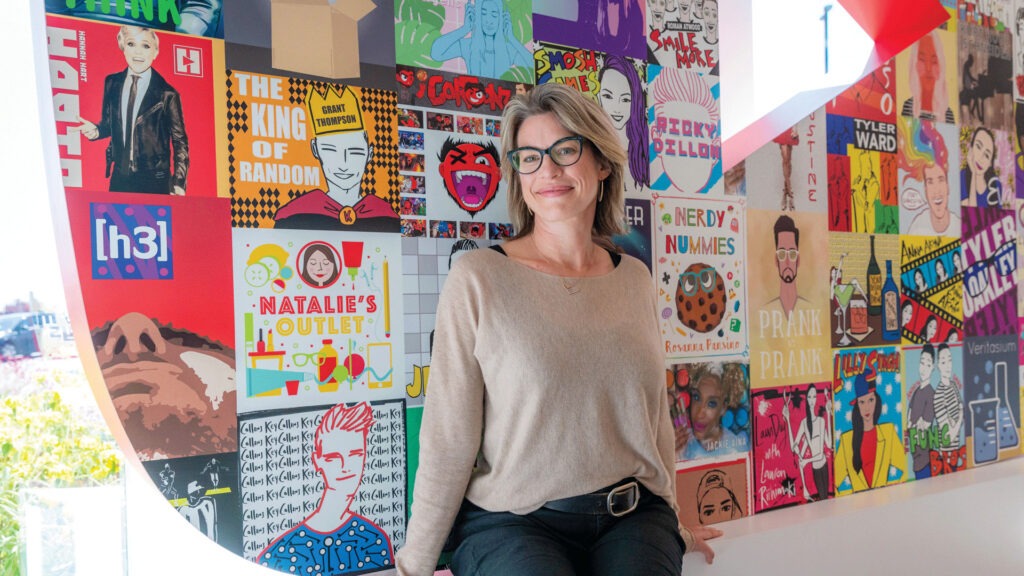 Danielle Tiedt standing in front of wall with colorful depictions of Youtubers
