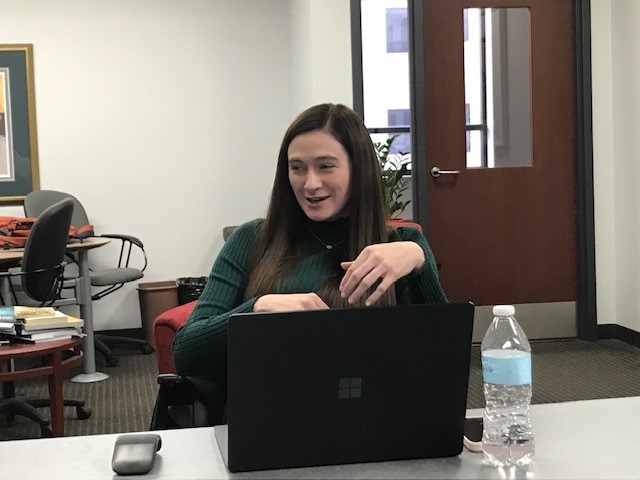 Jenna Herr addressing the MBA students while seated in front of her laptop