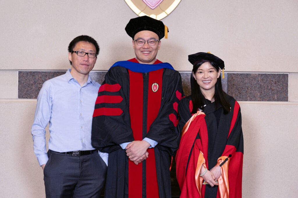 Real Estate faculty pose with a recent PhD graduate at a hooding ceremony