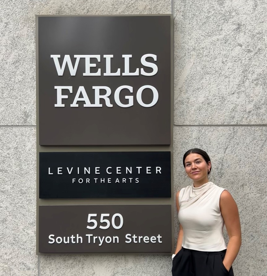 Madison Wescott standing with hands in her pockets next to a Wells Fargo sign