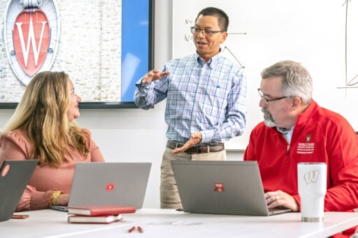 Professor Allen Li speaks with students in the classroom.