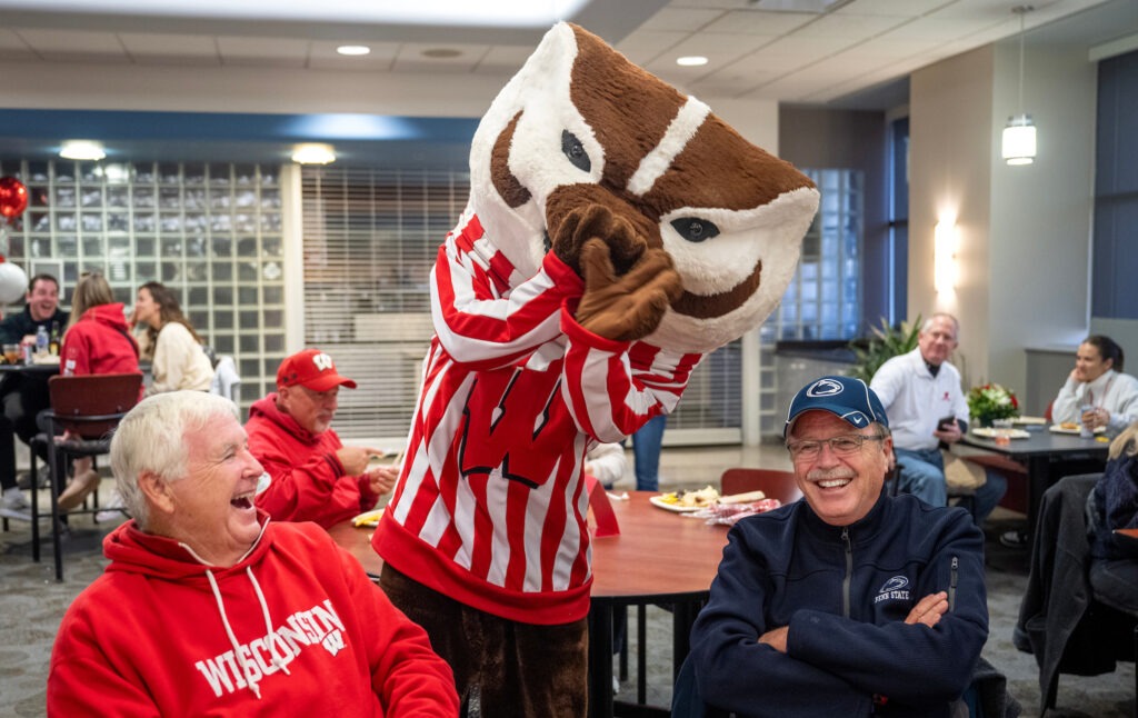 There’s a Nittany Lion in Grainger Hall! Bucky Badger teases Penn State fan Steve Falke while his friend, Jim Rennes (BS ’72, MBA ’75), cracks up! 