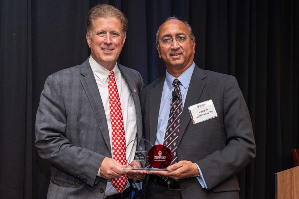 Dan Kelly, now retired after an extraordinary career at American Family Insurance, is presented with the Distinguished Business Alumni Award from Dean Samba.