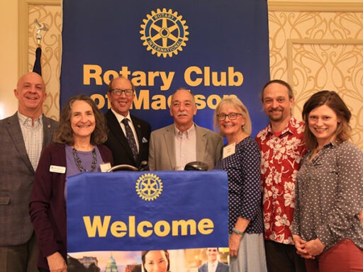 Donald Miner standing at a podium with six other people