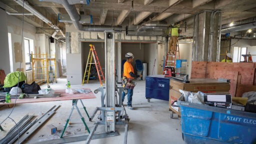 Two construction workers working on the Grainger Hall renovations