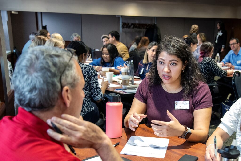 A man and a woman sit and talk at a table.