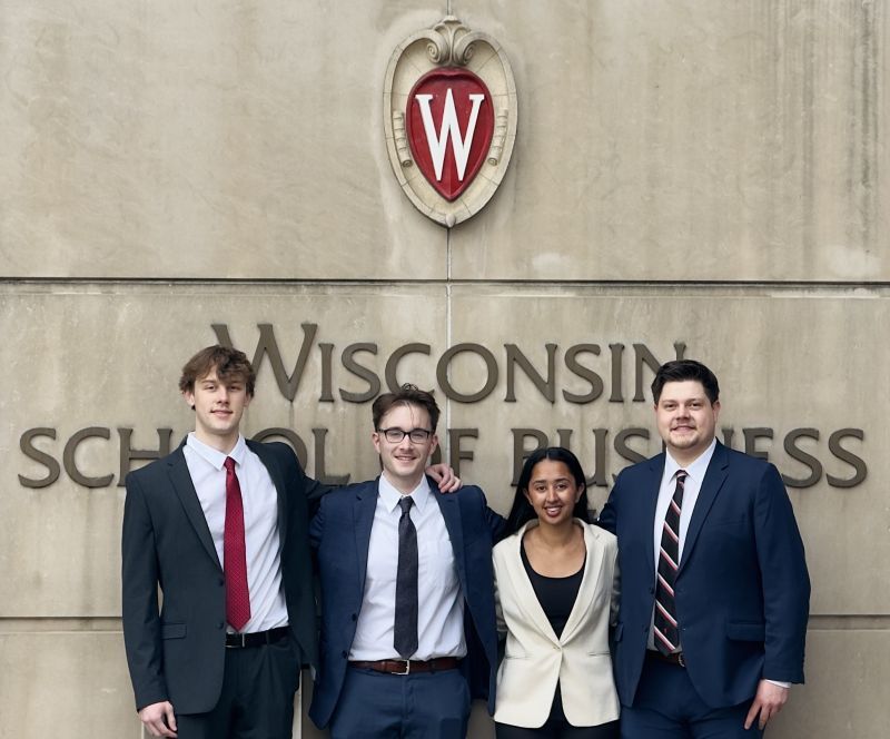 (Left to right) Luke Anderson, Alexander Lynn, Amanpreet Sehra, and Logan Nyborg together in front of the Wisconsin School of Business Sign