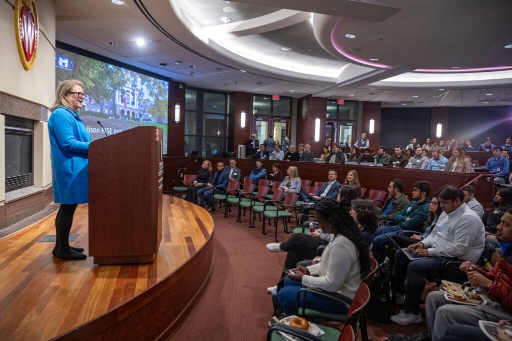 Page Moreau presenting behind podium in front of a seated audience.