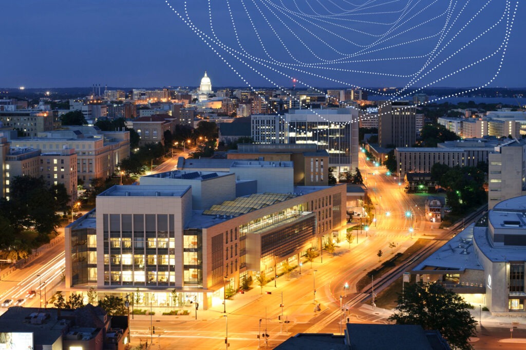 A birds-eye-view of UW–Madison campus at night, with the Wisconsin Institute for Discovery in front.