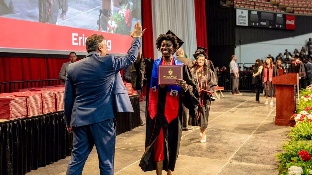 A graduate high-fives faculty member Dani Bauer.
